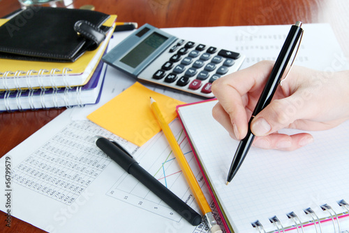 Woman hand with pen on worktable background