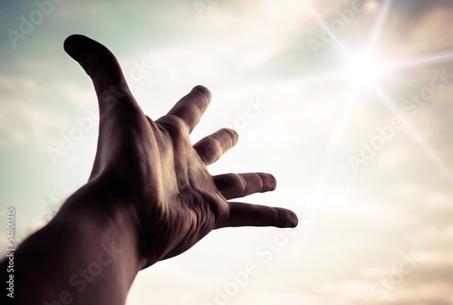 Canvas Print Hand of a man reaching to towards sky. Color toned image.