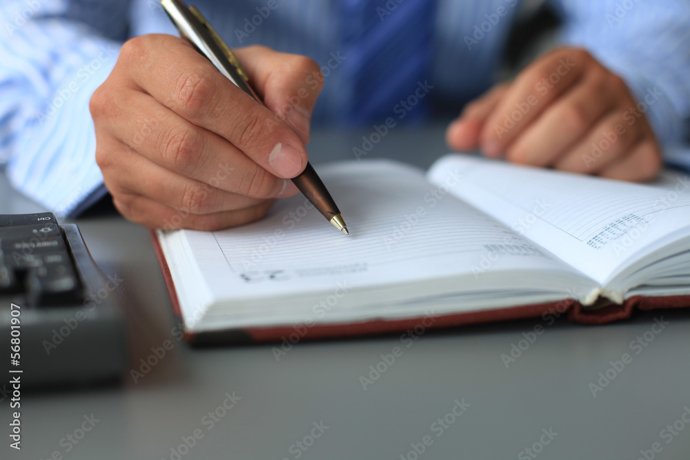 Businessman makes a note in notebook