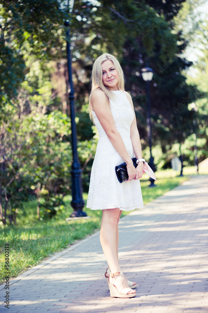 Beautiful young blond woman in a white dress outdoors Beautiful young blond woman in a white dress outdoors