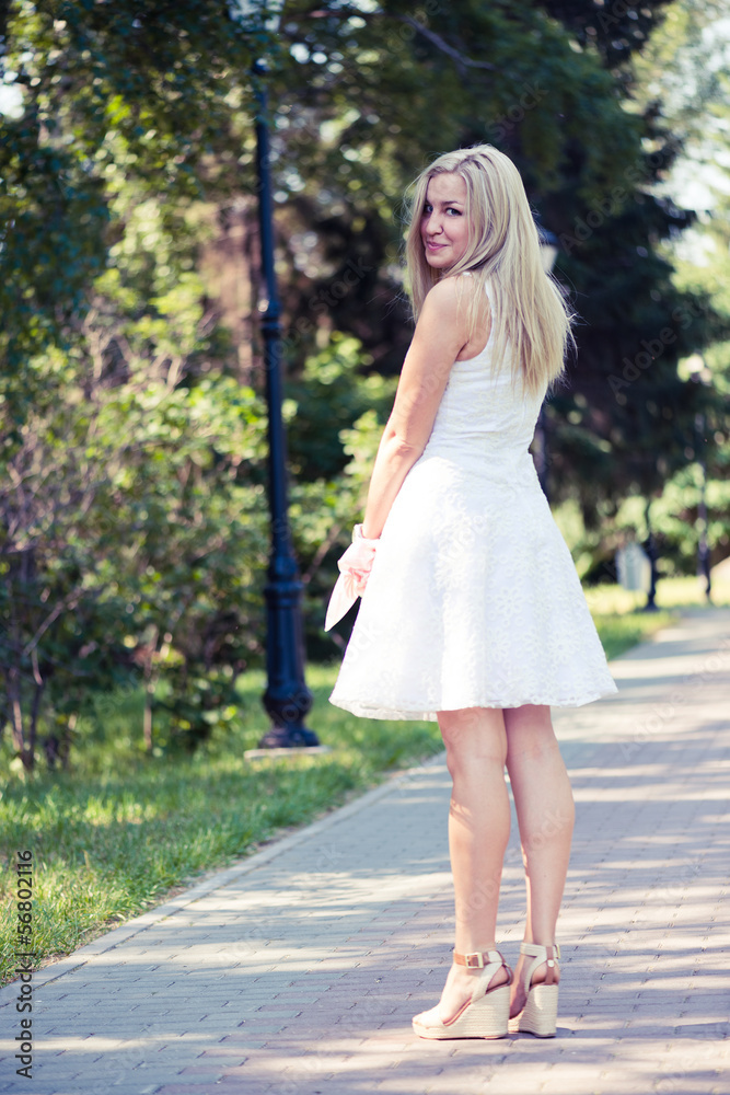 Beautiful young blond woman in a white dress outdoors Beautiful young blond woman in a white dress outdoors