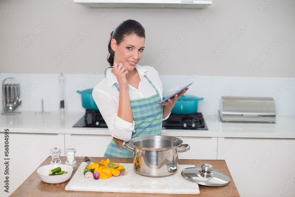 Happy gorgeous woman wearing apron using tablet Happy gorgeous woman wearing apron using tablet