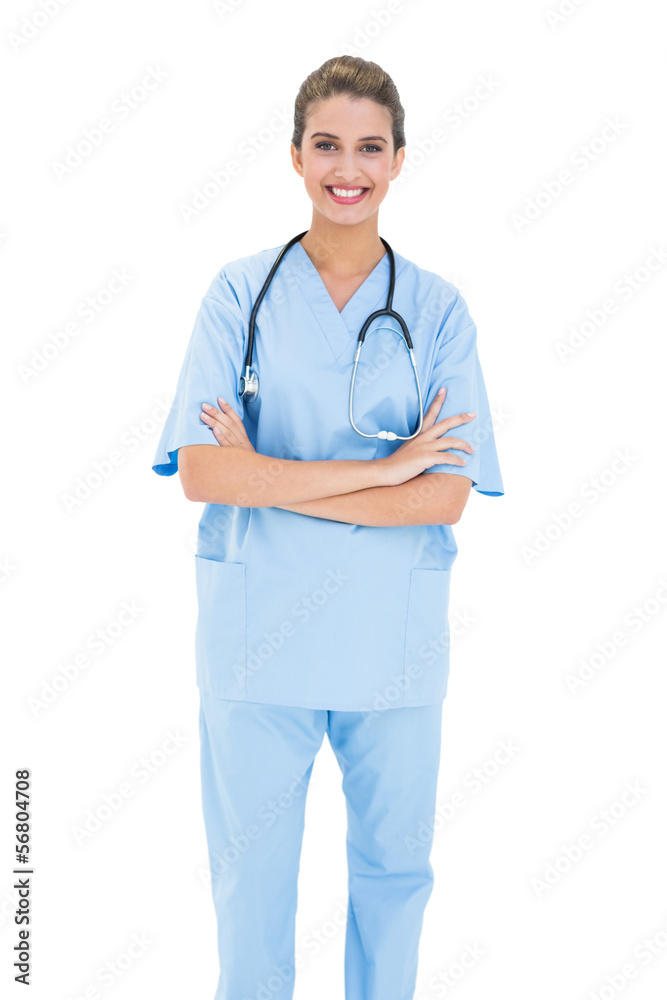 Smiling brown haired nurse in blue scrubs posing with arms cross Smiling brown haired nurse in blue scrubs posing with arms cross