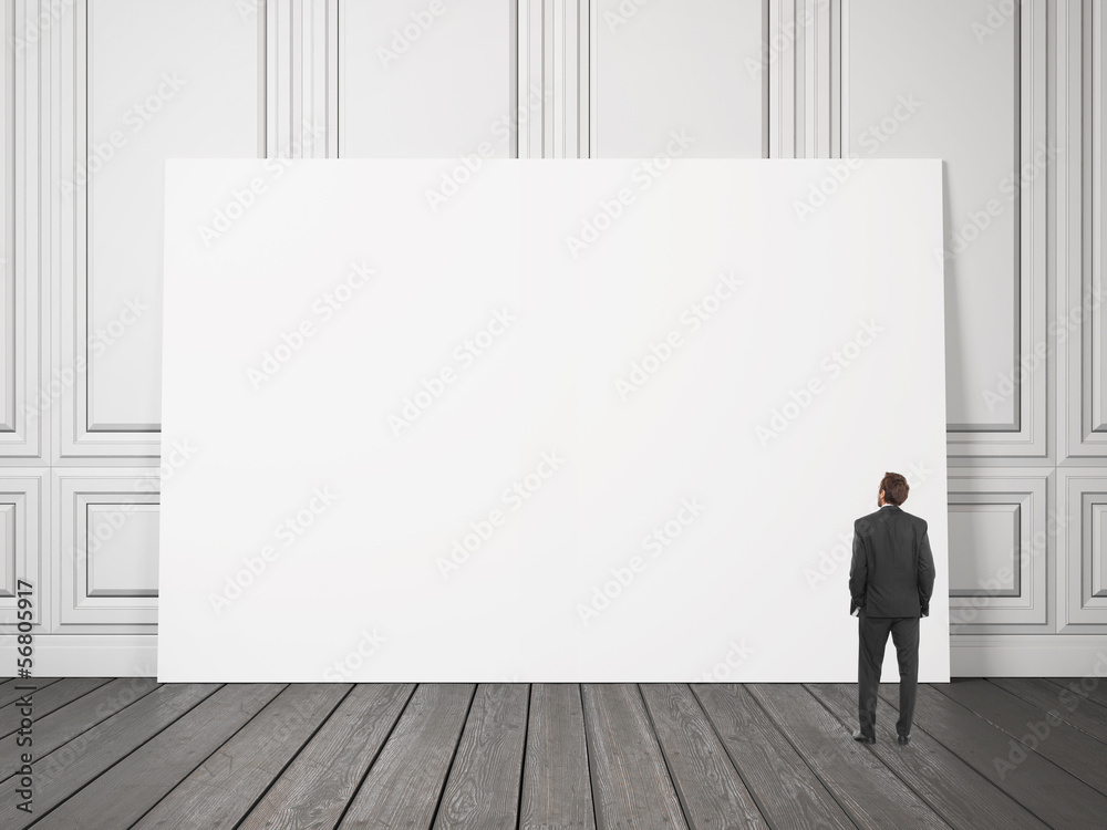 businessman looking at large blank poster businessman looking at large blank poster