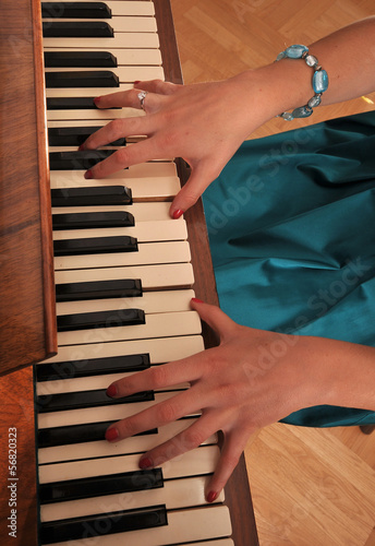 Dłonie pianistki na klawiszach pianina