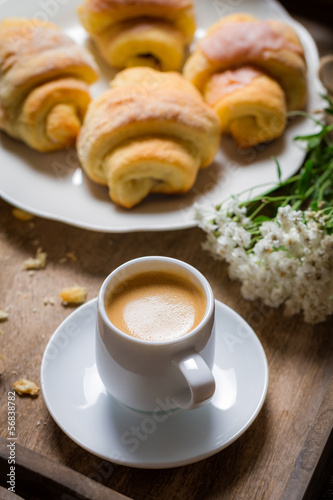 Breakfast in bed with espresso, flower and croissant