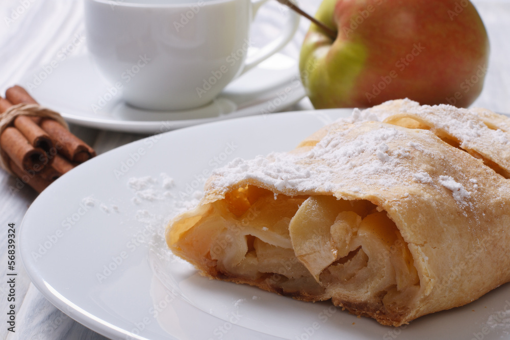 Apple pie with cinnamon on the white plate closeup