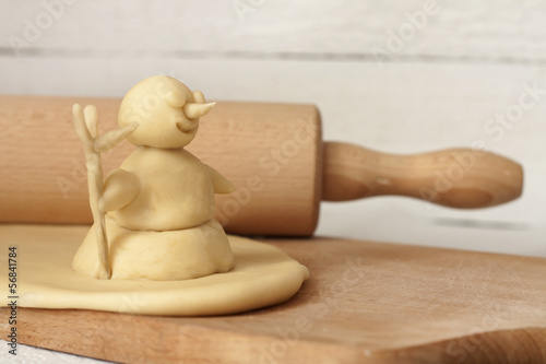 Christmas baking concept with dough snowman and rolling pin