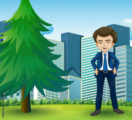 A happy businessman standing near the pine tree