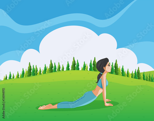 A young lady doing yoga at the hilltop