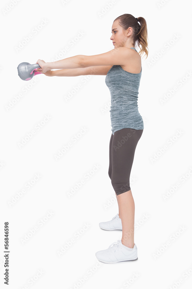 Young woman working with a kettle bell