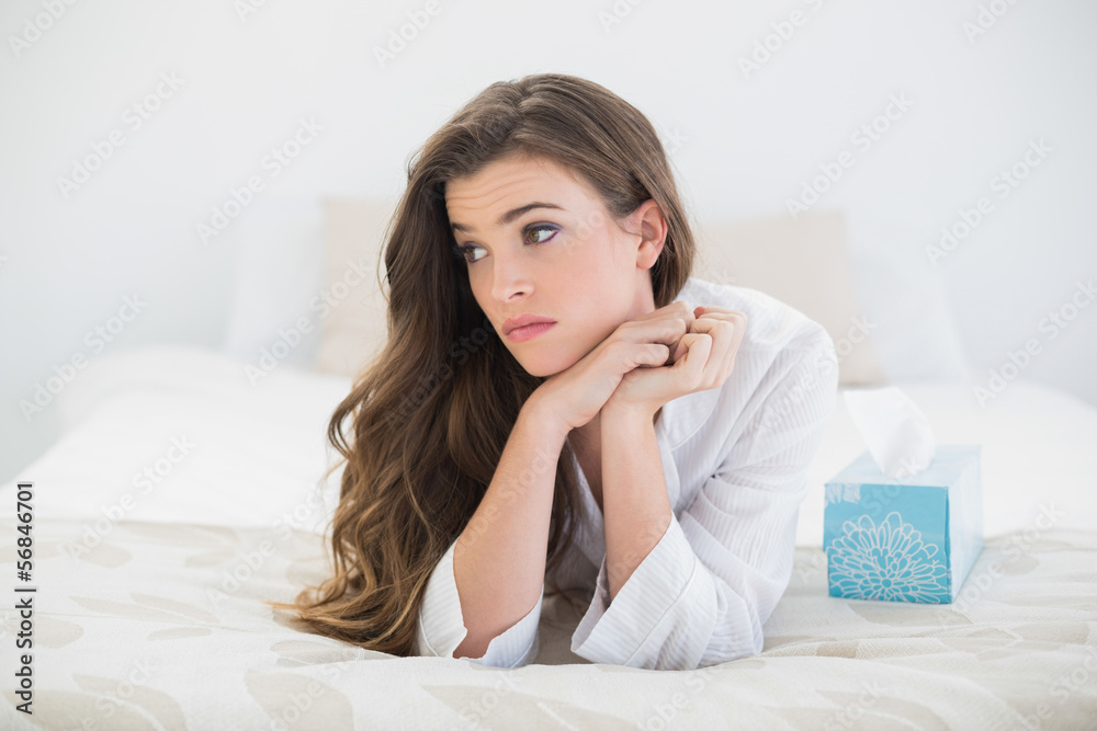 Beautiful casual brown haired woman in white pajamas lying on he Beautiful casual brown haired woman in white pajamas lying on he