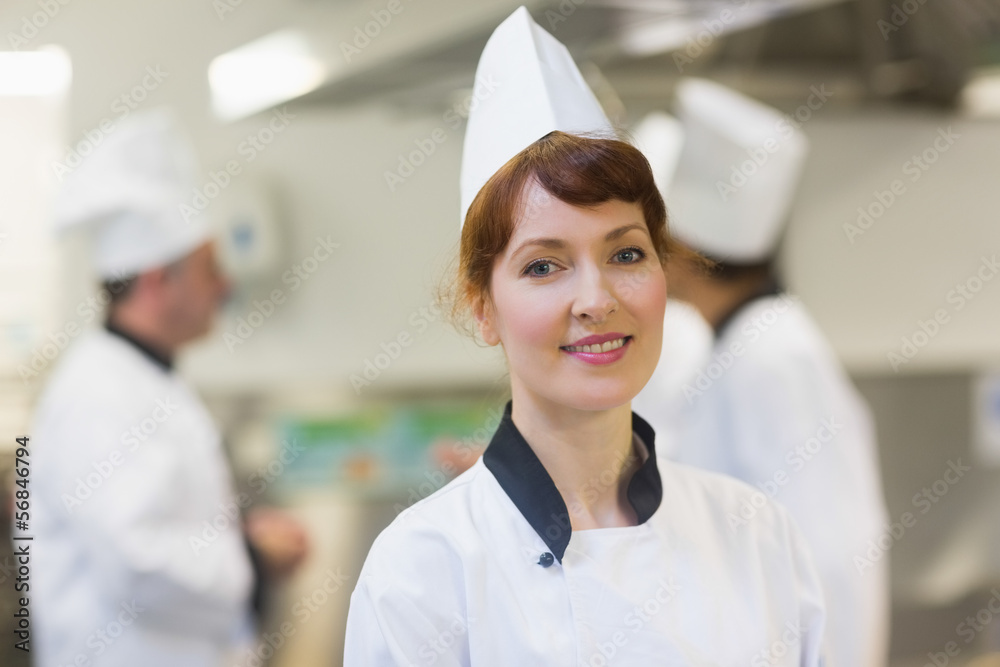 Smiling female chef posing in a kitchen