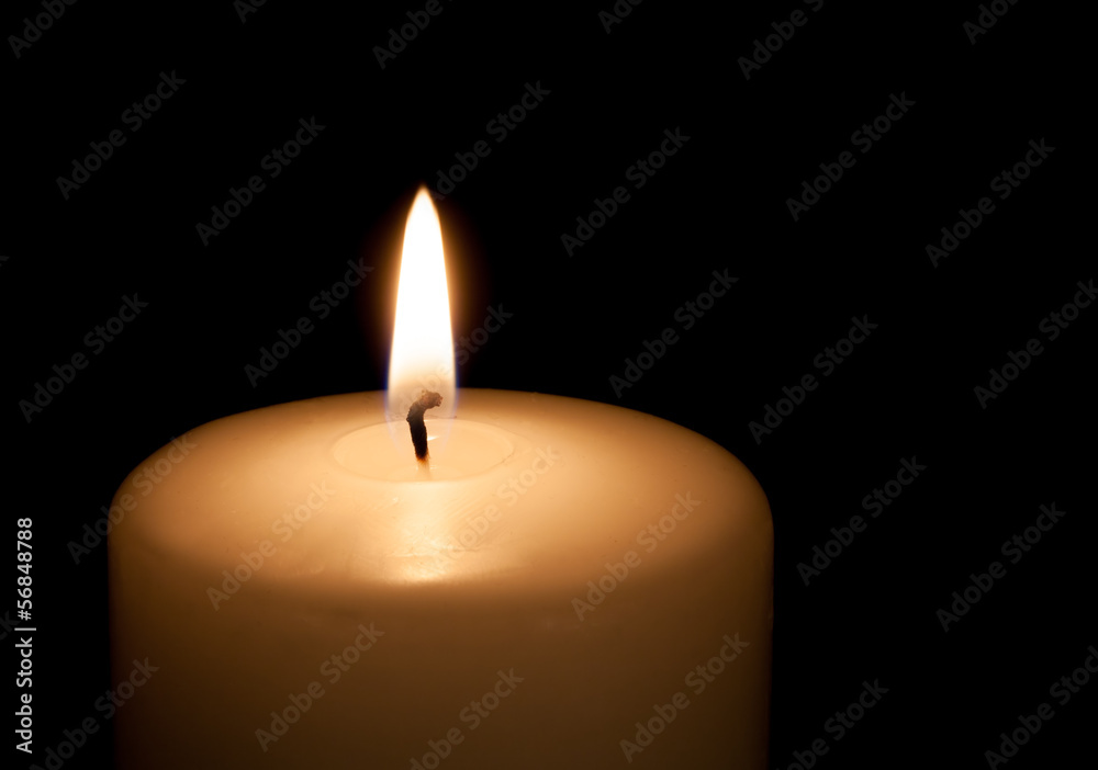 White candle on black background with copy space for text White candle on black background with copy space for text