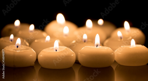 White candles on a black reflecting background