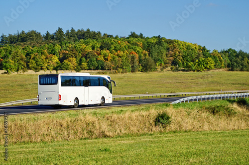 White bus on the road in the countryside