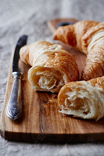 Croissant and a table knife on wooden chopping board © B.G. Photography