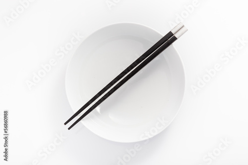 chopsticks in empty bowl isolated on a white background