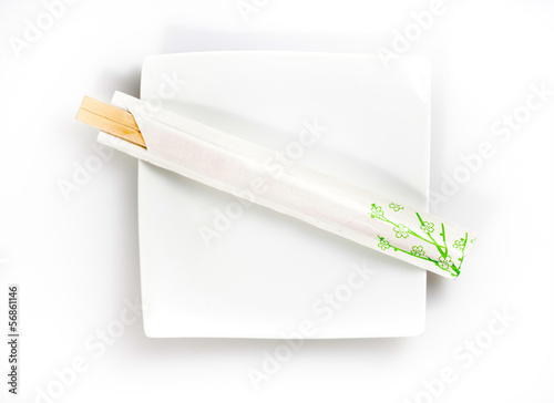 disposable chopsticks on a plate isolated on a white background photo