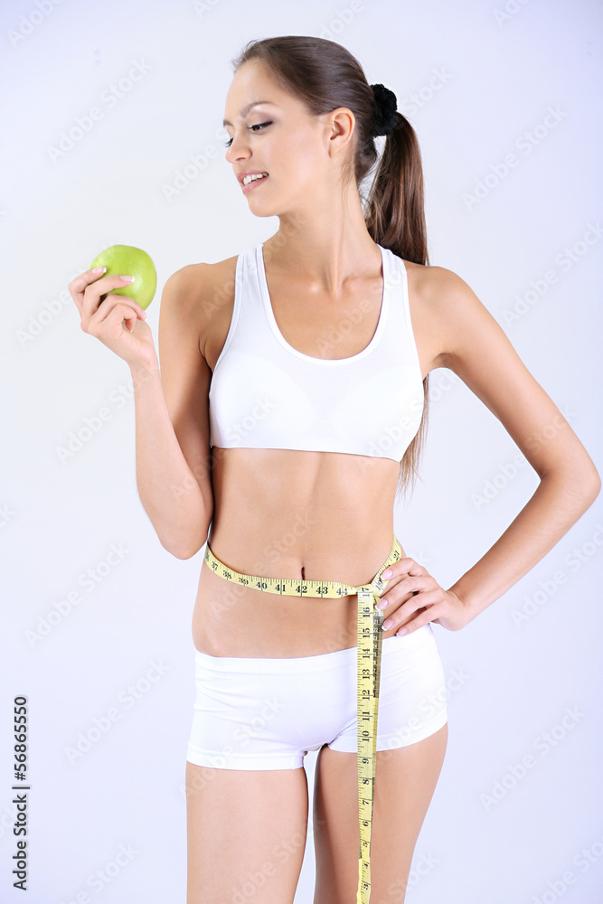 Slim girl with centimeter gray background Slim girl with centimeter gray background