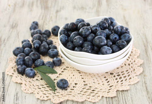 Blueberries in plates on napkin on wooden background