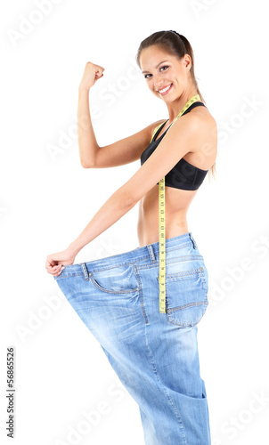 Slim girl in big jeans isol...