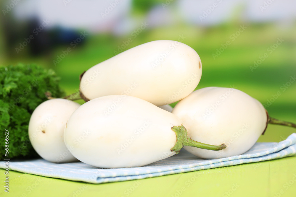 Fresh eggplants on table on bright background Fresh eggplants on table on bright background