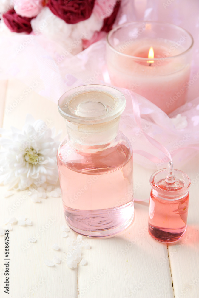 Glass bottle with color essence, on wooden background Glass bottle with color essence, on wooden background