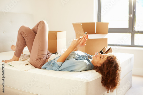 Woman Sending Text Message Having Moved Into New Home