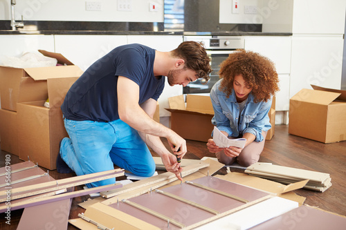 Tableau sur toile Couple Putting Together Self Assembly Furniture In New Home