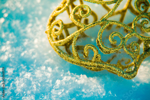 Golden Christmas ornament in the snow © Vira Monastyrska