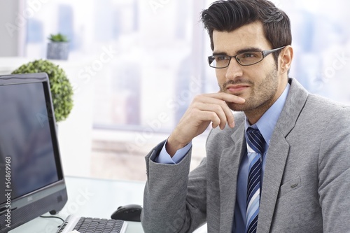 Handsome businessman sitting at desk