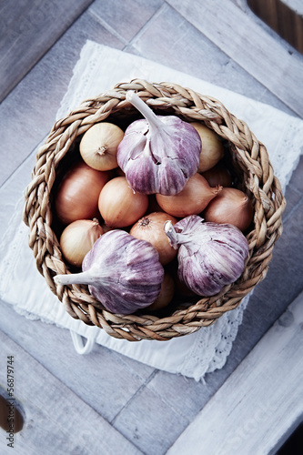 Onions and garlic bulbs in a rustic basket