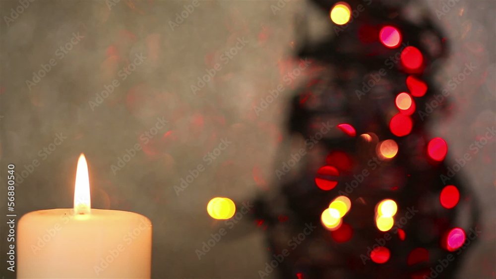 Burning candle with christmas tree in background Stock Video | Adobe Stock