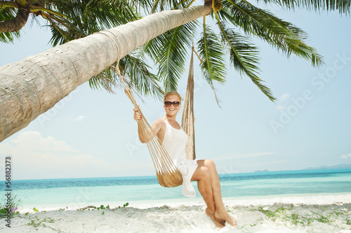 Obraz na plátně view of nice young lady swinging  in hummock on tropical beach
