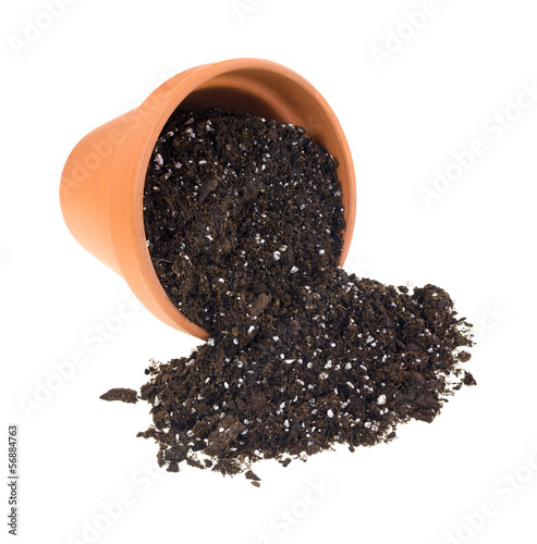 Organic potting soil spilling from a clay pot