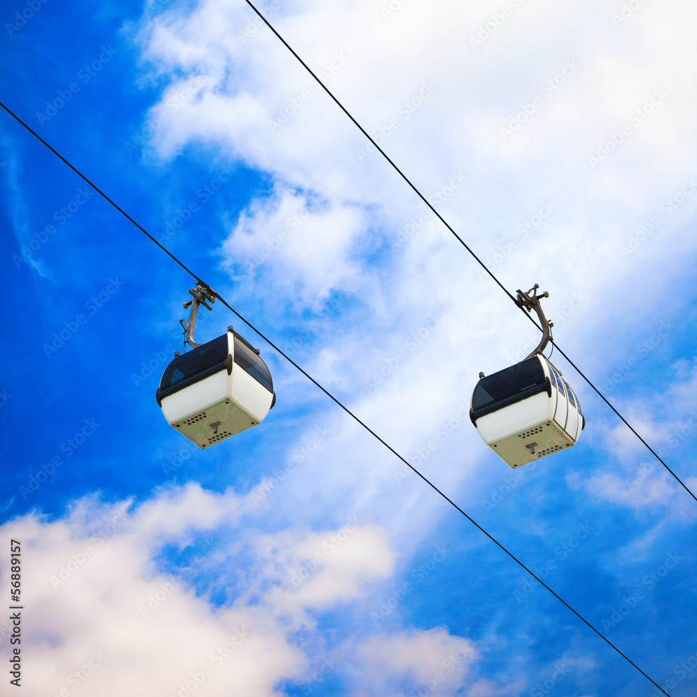 Two cable car on a partly cloudy sky background Two cable car on a partly cloudy sky background