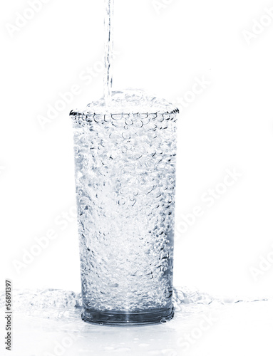 pouring water into the glass isolated on a white background