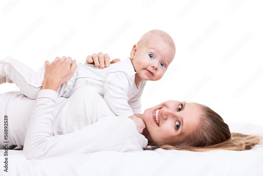 Smiling young woman holding baby son while lying on back Smiling young woman holding baby son while lying on back