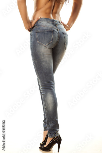 view from behind on the pretty female legs in jeans on white