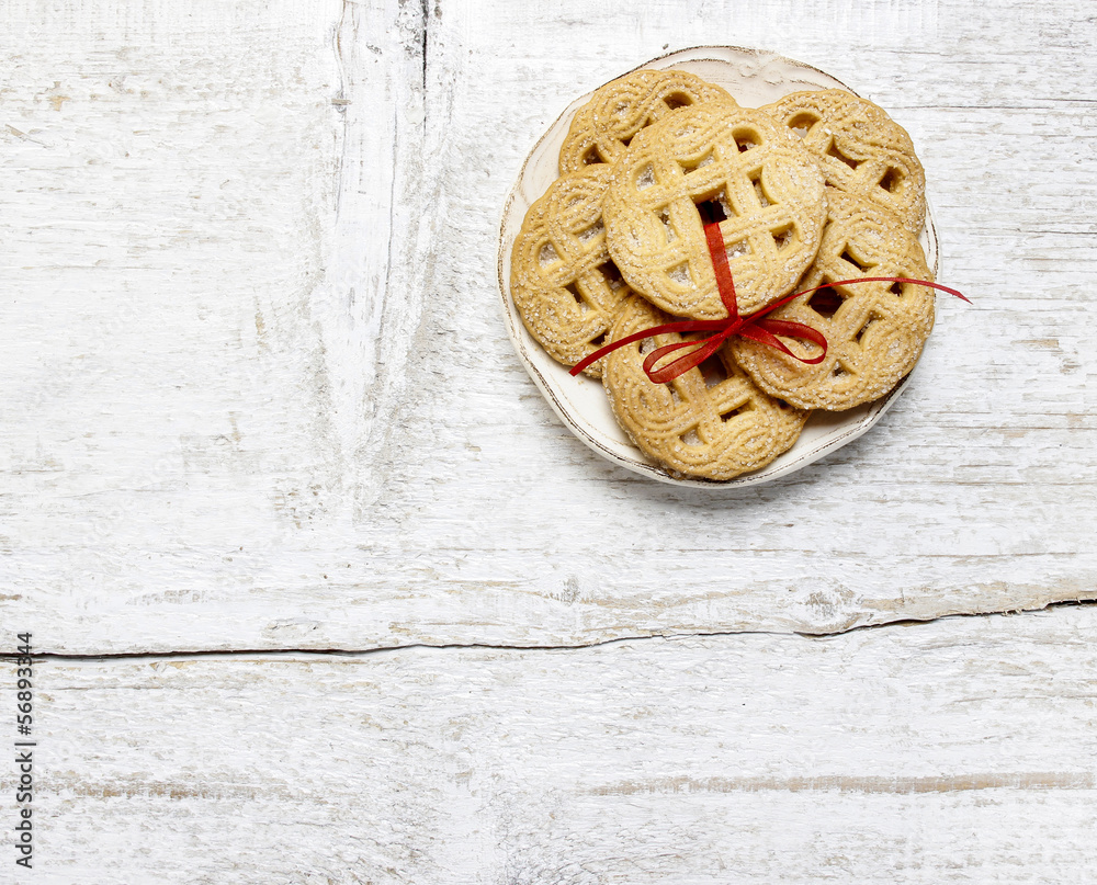 Fototapeta premium Top view of cookies with red bow on white wooden table