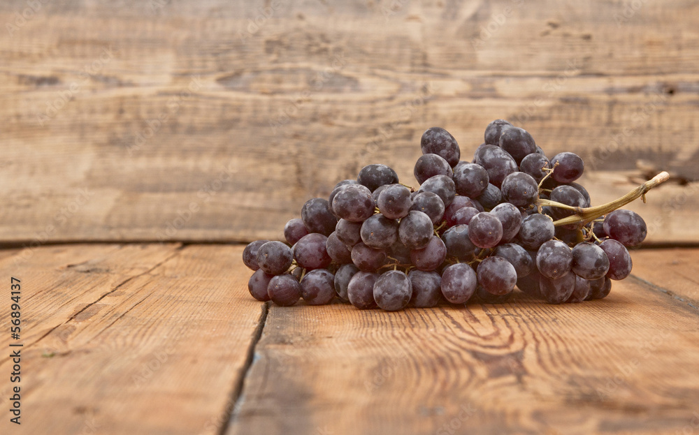 Bunch black grapes on old wooden table Bunch black grapes on old wooden table