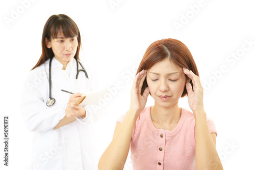 診療中の女医と頭痛を訴える患者