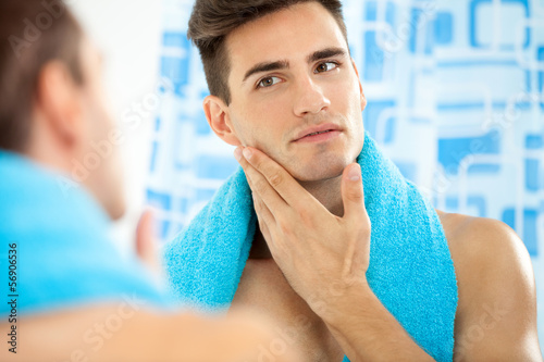 Man touching his face after shaving photo