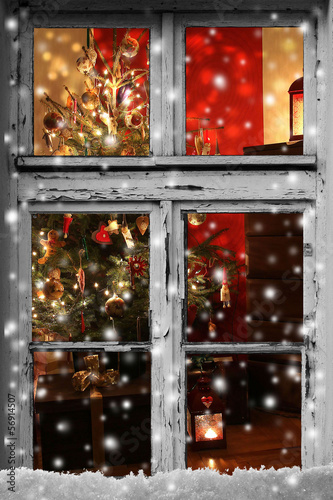Christmas lights seen through a wooden cabin window