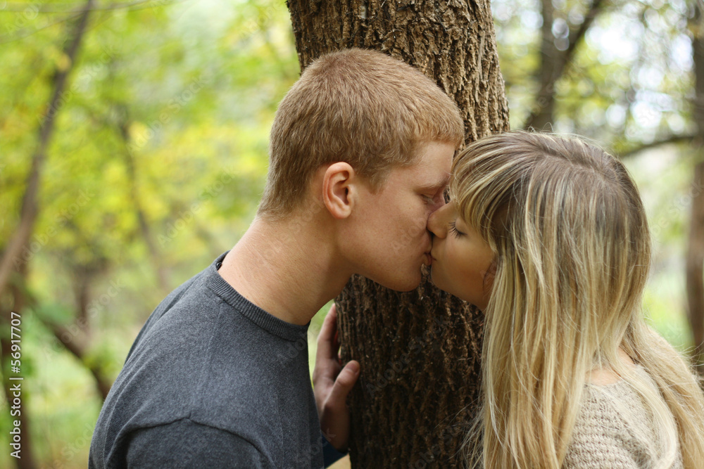 autumn portrait of kissing young couple near the wood autumn portrait of kissing young couple near the wood