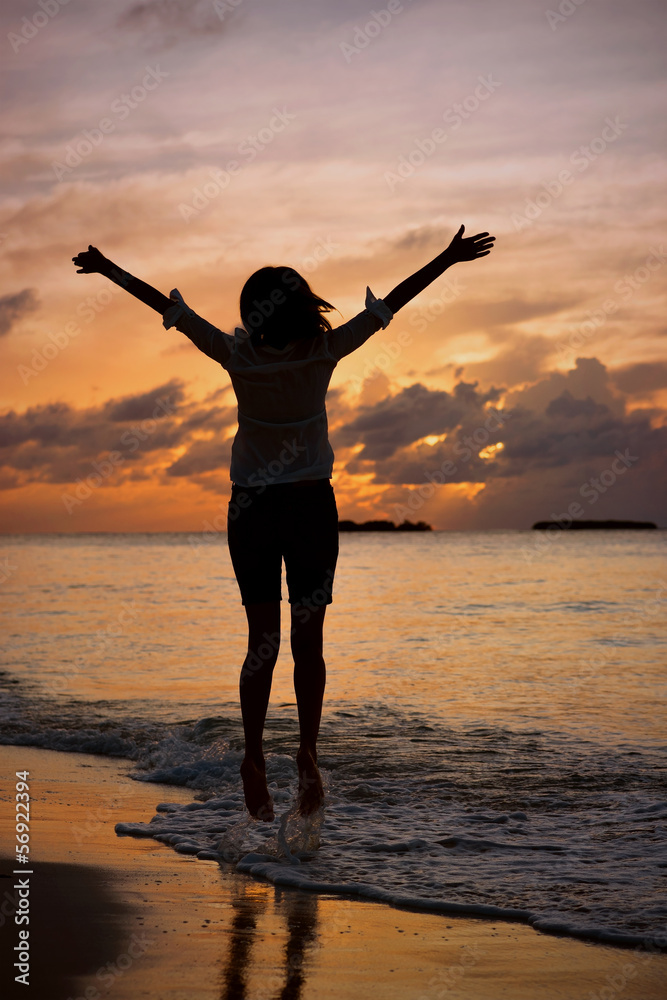 Fototapeta premium Silhouette of a girl at sunset near the shore of Indian Ocean