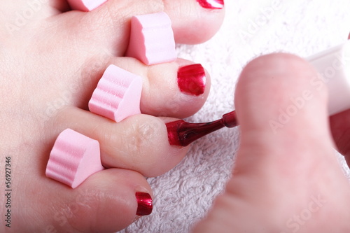 female feet red polished nails