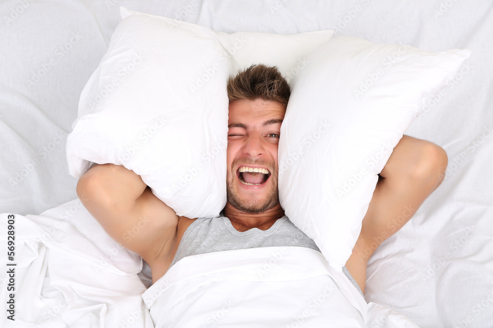 Handsome young man in bed