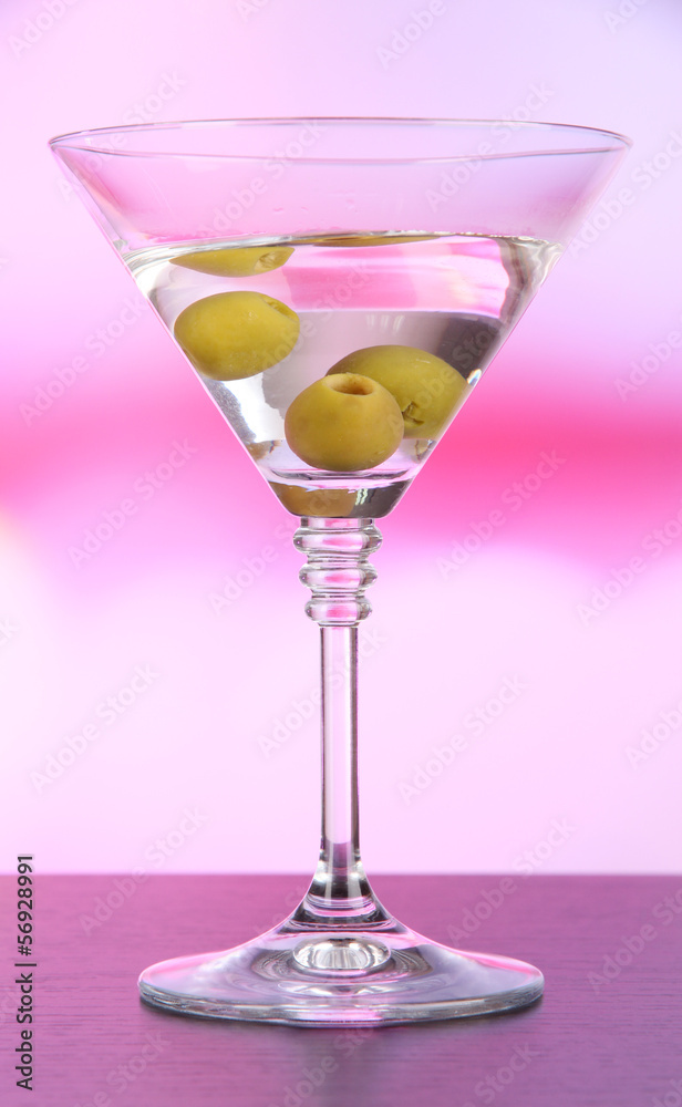 Martini with green olives on table in bar